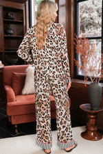 Load image into Gallery viewer, Person wearing a leopard print outfit in a room with a pink sofa and window.
